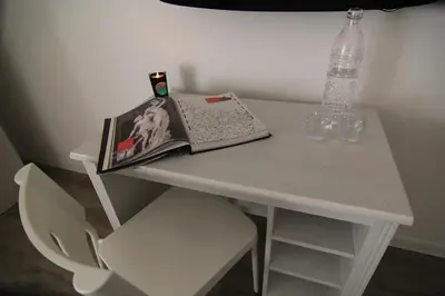 a table with a magazine and a bottle and glasses on it at Cornelia House in Rome