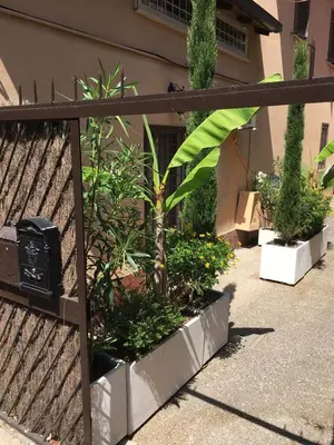 a fence with a bunch of plants in front of a building at Casale 2.0 in Rome