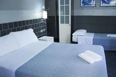 a hotel room with two beds with towels on the bed at Hotel Agorà in Rome