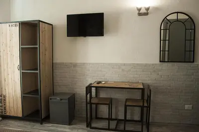 a table with two chairs and a television on a wall at Hotel Agorà in Rome
