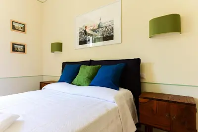 a bedroom with a bed with blue and green pillows at Bright and Comfy 3 bedroom apt in Monti in Rome