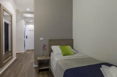 a bedroom with a bed with a green pillow on it at La Palma in Rome