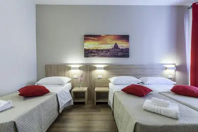 a hotel room with two beds with red pillows at La Palma in Rome