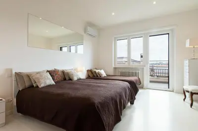 a bedroom with two beds and a mirror on the wall at Vatican Holiday Apartment 307 in Rome