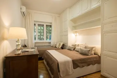 a bedroom with a bed and a desk and a window at Vatican Holiday Apartment 307 in Rome