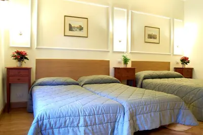 a bedroom with two beds with blue comforters at Domus Cavour Guest house in Rome