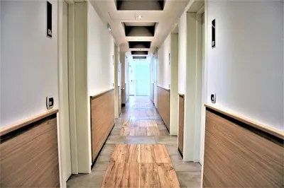 a long hallway with wood floors and wooden doors at Hotel Paolo II in Rome