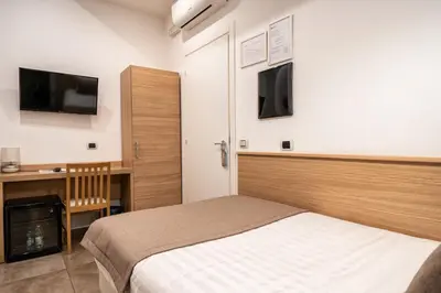 a bedroom with a bed and a desk and a tv at Hotel Paolo II in Rome