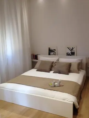 a large white bed with a tray on it at White Apartment in San Giovanni in Rome