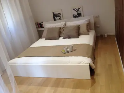 a large white bed with two candles on it at White Apartment in San Giovanni in Rome