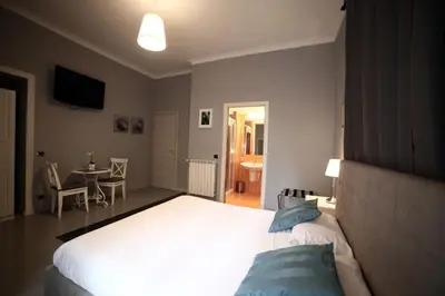 a bedroom with a large white bed and a table at Dhome B&B in Rome