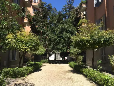an empty street in an apartment building with trees at Dhome B&B in Rome