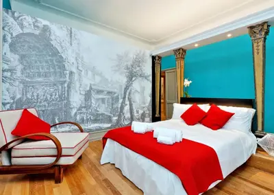 a bedroom with a large bed with a red blanket at Piranesi Charmsuite in Rome