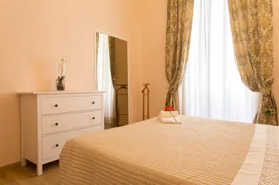 a bedroom with a bed and a dresser and a window at Amedeo Apartment in Rome
