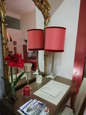 a table with two red lamps and a mirror at Rome in your heart - Spagna apartment in Rome