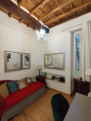 a living room with a couch and two mirrors at Cozy Navona Apartment in Rome