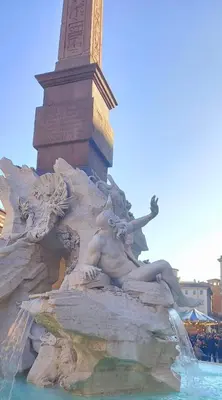 a statue of a man sitting in a fountain at Cozy Navona Apartment in Rome