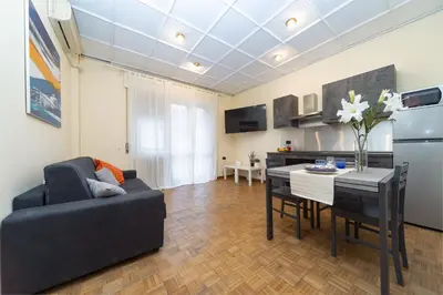 a living room with a couch and a table and a kitchen at VATICAN Gregory Apartment in Rome