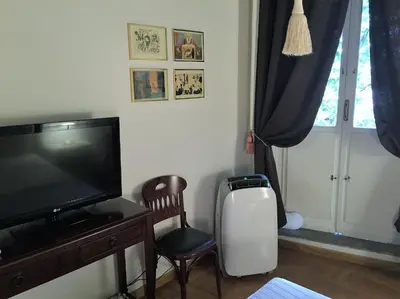 a living room with a flat screen tv and a chair at MGPgroup Guest House Navona 2 in Rome