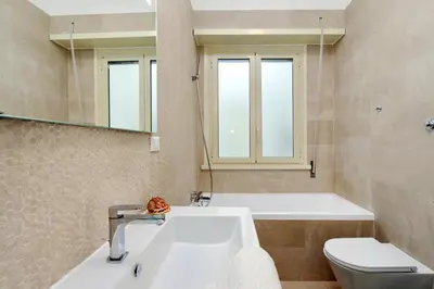 a bathroom with a sink and a tub and a toilet at Oksana's Bernadette Apartment in Rome