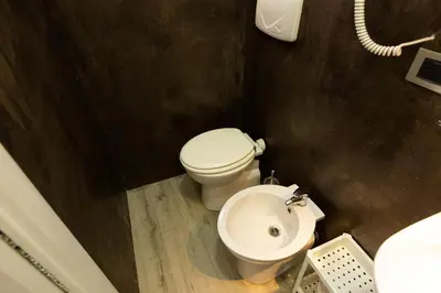 a small bathroom with a toilet and a sink at Termini Central Inn in Rome