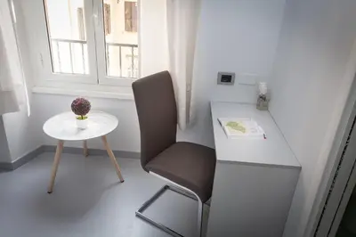 a desk and a chair and a table and a window at Termini Central Inn in Rome