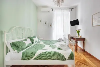 a bedroom with a bed with a green and white comforter at NOH Family Nest in Rome