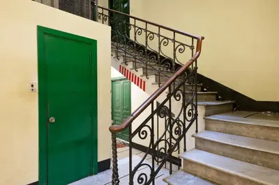 a green door on the side of a building with stairs at NOH Family Nest in Rome