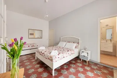 a bedroom with two beds and a vase of flowers at NOH Family Nest in Rome
