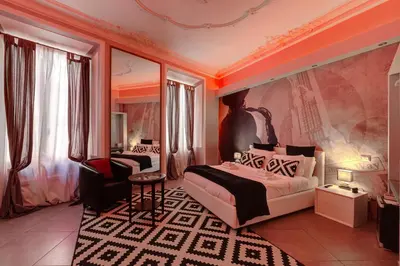 a bedroom with a king sized bed and a chair at Maison Degli Artisti Suites in Rome