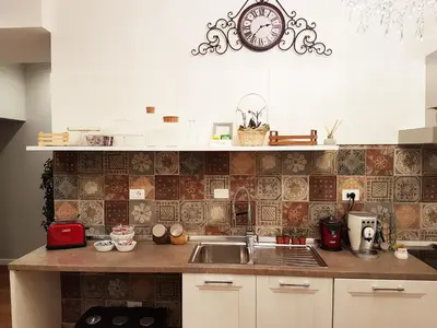 a kitchen with a sink and a clock on the wall at More Cola di Rienzo B&B in Rome