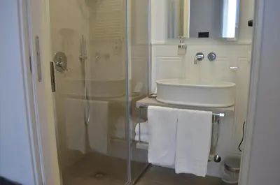 a bathroom with a glass shower and a sink at At your Place in Rome
