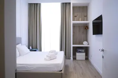 a hotel room with two beds and a television at Aureliana Luxury Apartments in Rome