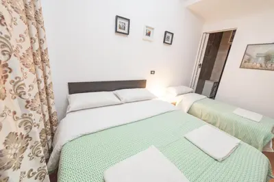 a bedroom with two beds with green and white sheets at Lemei House in Rome
