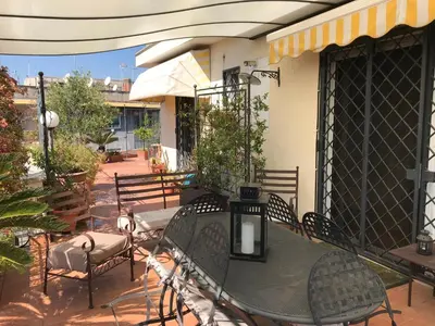 a patio with a table and chairs on a porch at Roma Suite Balduina in Rome