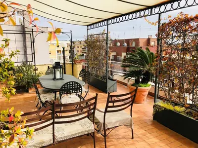 a patio with a table and chairs on a balcony at Roma Suite Balduina in Rome