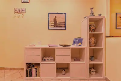 a white book shelf in a room with books at TOM'S HOUSE in Rome