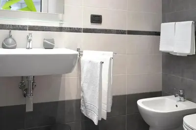 a bathroom with a sink and a toilet and towels at J24 B&B in Rome