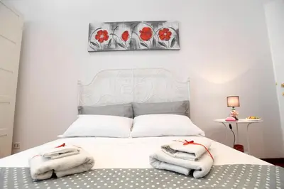 a bedroom with a white bed with towels on it at Big House Colosseum in Rome