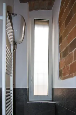 a bathroom with a window and a brick wall at La Casa di Marti in Rome