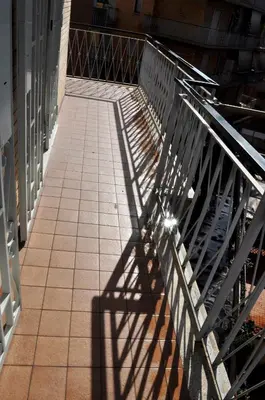 a shadow of a fence on a sidewalk at 