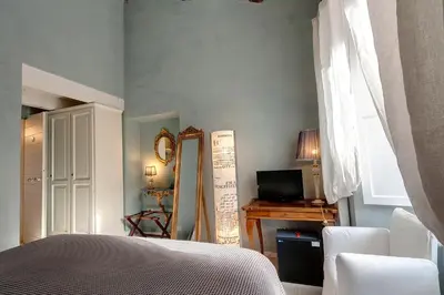 a bedroom with a bed and a mirror and a television at LM Suites Spagna in Rome