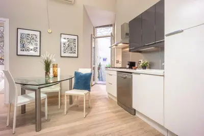 a kitchen with a glass table and chairs in a room at Private Apartment Colosseum in Rome