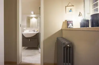 a bathroom with a toilet and a sink and a radiator at Private Apartment Colosseum in Rome