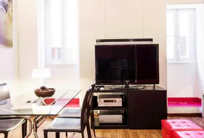a living room with a large television on a black entertainment center at RSH Balestrari Apartments in Rome