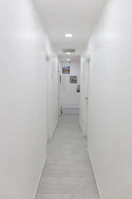 a corridor of an empty hallway with white walls and tile floors at Metronia Guest House in Rome