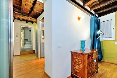 a room with a table with a blue vase on it at Parione Charme - My Extra Home in Rome