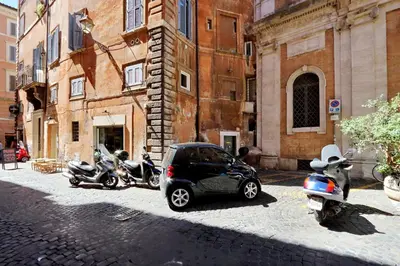 a small car parked next to motorcycles and a building at Parione Charme - My Extra Home in Rome
