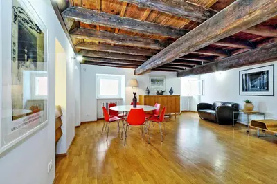 a living room with a table and red chairs at Parione Charme - My Extra Home in Rome