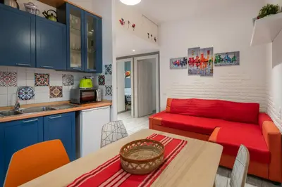 a living room with a red couch and a table at Lilli Home Holidays in Rome